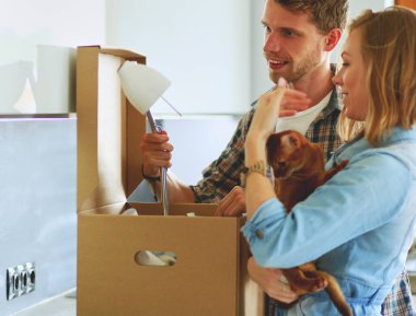 Genç bir çift yeni evde büyük karton kutu taşıyan. Ev taşıma. Genç Çift.