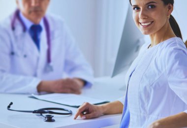 İki doktor hastanedeki konferans odasında gülümsüyor.