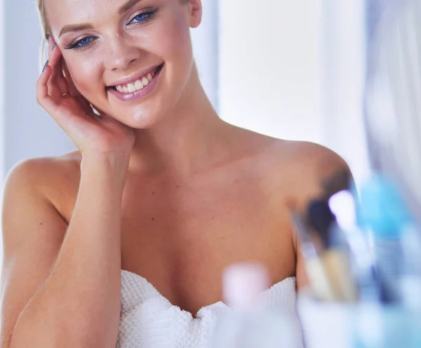 Güzel Genç Bir Kadın Yüzüne Dokunuyor Aynaya Bakarken Gülümsüyor — Stok fotoğraf