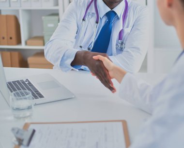 Ofiste tokalaşırken gülümseyen iki genç doktor.