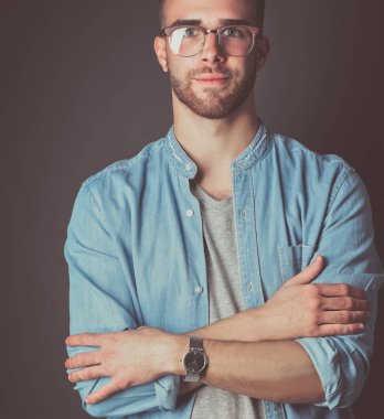 Mutlu bir casual adam ayakta karanlık bir arka plan üzerinde izole portresi. Yakışıklı erkek poz