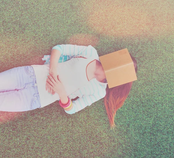 美丽的年轻女子躺在绿草上 — 图库照片