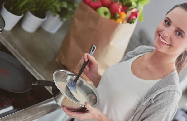 Mujer Joven Prepara Panqueques Cocina Mientras Está Pie Cerca Mesa —  Fotos de Stock