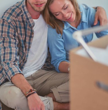 Genç bir çift yeni ev içinde hareket. Oturma ve açma sonra rahatlatıcı. Bir şey üstünde laptop arıyorum. Genç Çift.