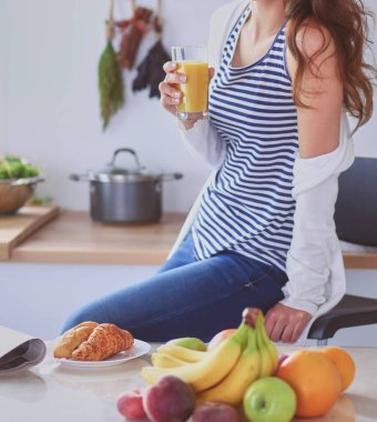 Genç bayan mutfakta masanın yanında oturuyor..