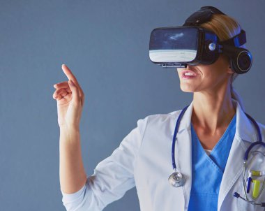 Sanal gerçeklik gözlüğü takan kadın doktor beyaz arka planda izole edilmiş.