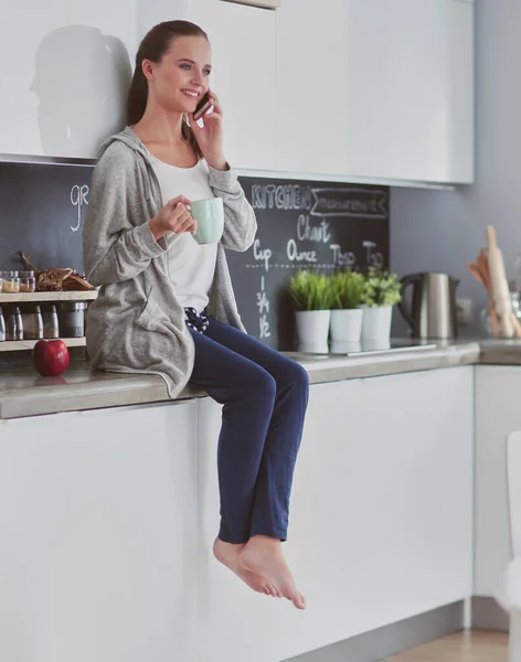 Vrouw Met Behulp Van Mobiele Telefoon Zitten Moderne Keuken — Stockfoto