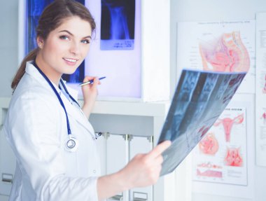 Genç, profesyonel kadın doktor hastaların röntgenlerini çekiyor..