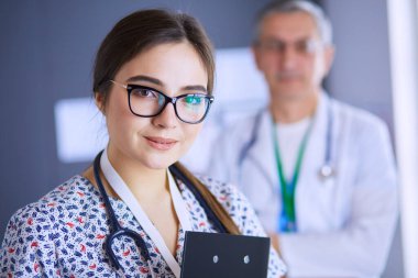 Bir doktor ekibi, kadın ve erkek, ofiste bekliyorlar..