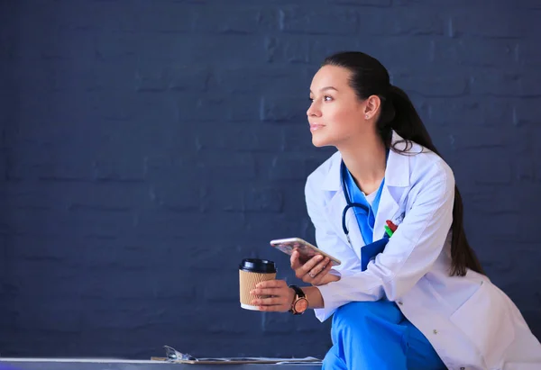 Vrouwelijke Arts Zit Met Mobiele Telefoon Het Drinken Van Koffie — Stockfoto