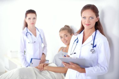 Hastanede hastaların yanında duran iki kadın doktor..