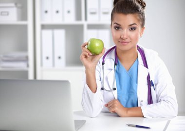 Yeşil bir elma tutan kadın doktor. .