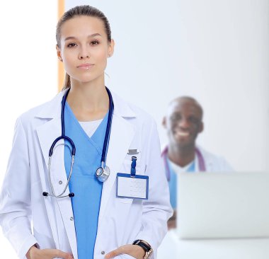 Masada oturan gülümseyen güzel genç bayan doktor.