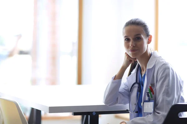 Prachtige Jonge Glimlachende Vrouwelijke Arts Zittend Aan Het Bureau Vrouwelijke — Stockfoto