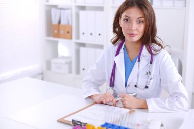 Kadın araştırmacı, beyaz şişeler ve şişelerle çevrili.