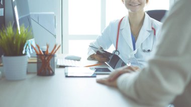 Bir doktor konuşuyor ve bir hastayı muayene ediyor..