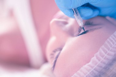 Kaşlar için kalıcı makyaj. Güzellik salonunda kalın kaşlı güzel bir kadın.