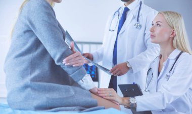 Doktor ve hasta tarama sonuçlarını tarama merkezinde tartışıyor.