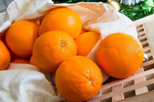 Vacances de Noël nature morte avec des oranges crues fraîches de gros plan sortant du panier — Photo