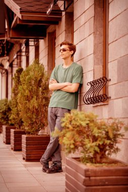 Duvarın yanında duran yakışıklı adam.