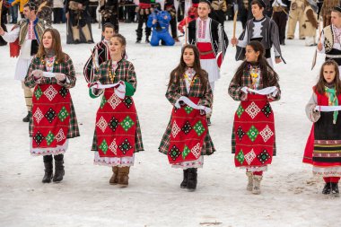 Razlog, Bulgaristan - 14 Ocak 2017: Starchevata festivalinde dans eden parlak kostümlü insanlar
