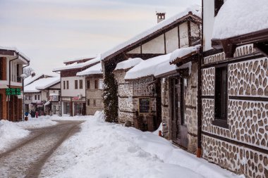 Bansko, Bulgaristan - 2 Şubat 2022: Eski kasaba kar yağışı Pirin sokağı manzarası, Bulgar kayak merkezindeki geleneksel evler