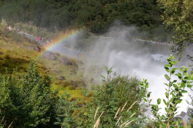 Olden, Norveç ve yeşil dağlardaki Briksdal veya Briksdalsbreen buzuluna giden yolda şelale ve gökkuşağı