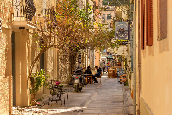 Nafplio, Greece - March 30, 2019: Old town street panorama with cosy cafe in Nafplion, Peloponnese