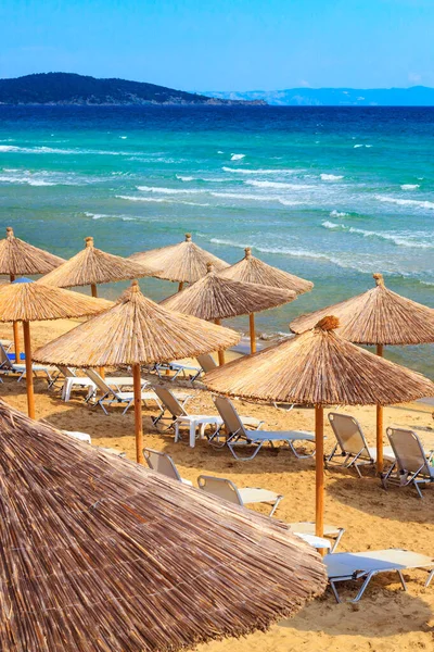 Sarti, Griechenland Strand Hintergrund mit Meereswellen und Sonnenschirmen — Stockfoto