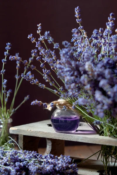 Herbal oil and lavender flowers still-life on wooden rustic background