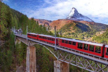 Zermatt, İsviçre. Köprüde Gornergrat kırmızı turist treni ve İsviçre Alplerinde Matterhorn zirvesi manzarası