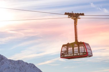 Chamonix Mont Blanc, Fransa - 28 Ocak 2015: Chamonix 'ten Aiguille du Midi' nin zirvesine kadar kablo araba kamarası ve pembe gün batımı gökyüzü, Fransız Alpleri