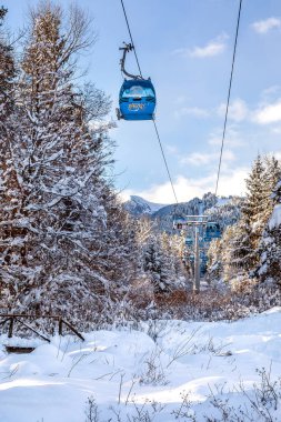 Bansko, Bulgaristan - 3 Şubat 2022: Kar yağışı sonrasında teleferik kabinleri, kar dağları ve ağaçlarla birlikte kış tatil beldesi