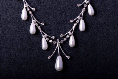 necklace with white pearls stones on the black background