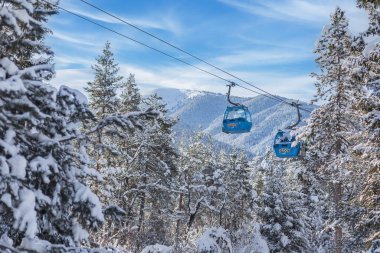 Bansko, Bulgaristan - 3 Şubat 2022: Kar yağışı sonrasında teleferik kabinleri, kar dağları ve ağaçlarla birlikte kış tatil beldesi