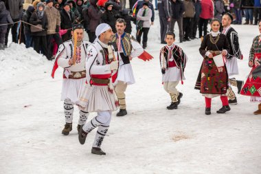Razlog, Bulgaristan - 14 Ocak 2017: Starchevata festivalinde dans eden parlak kostümlü insanlar
