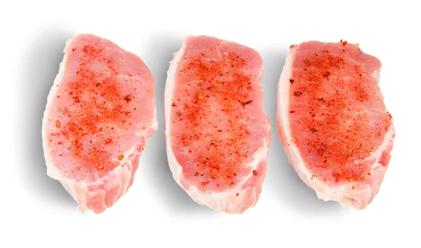 Tre pezzi di maiale crudo con spezie — Foto Stock