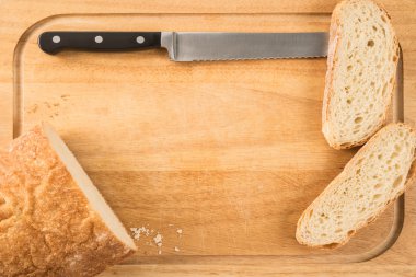 bir kesme tahtası üzerinde bıçakla ekmek