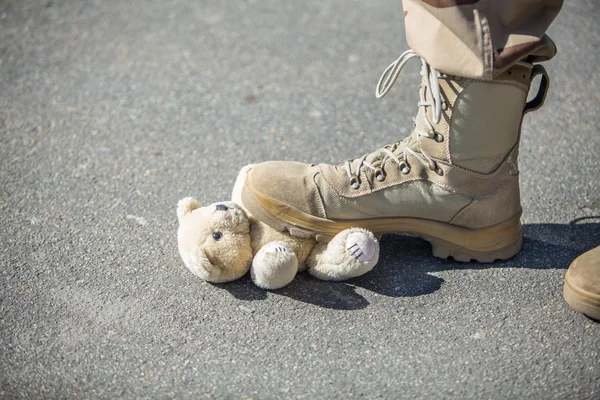 Military man set foot on a toy — Stock Photo, Image