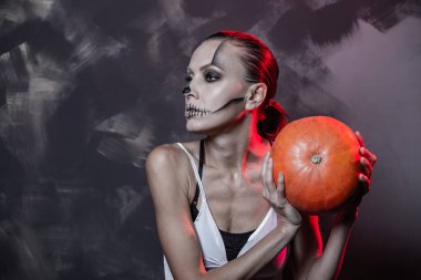 Cadılar Bayramı balkabaklı güzel cadı Koyu gri vintage duvarın üzerinde