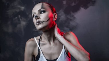 Parlak cadılar bayramı makyajı ve siyah beyaz kostümü olan güzel bir kadının portresi.