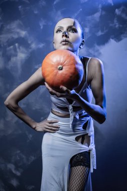 Parlak cadılar bayramı makyajı ve balkabağı ile güzel bir kadının portresi.