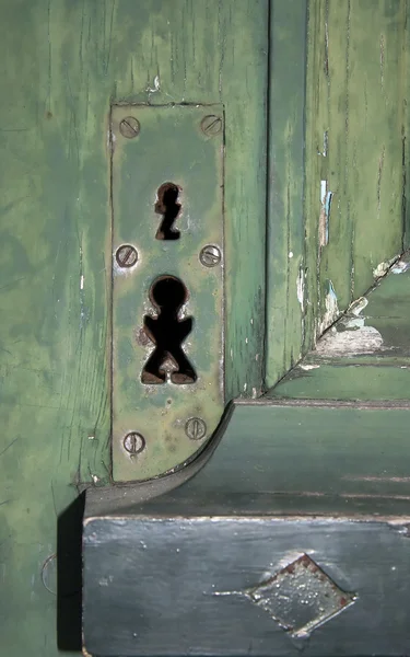 Vreemde sleutelgaten op een oude deur — Stockfoto