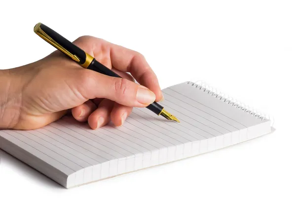 Female hand holding an elegant fountain-pen over reporter's bloc Royalty Free Stock Photos