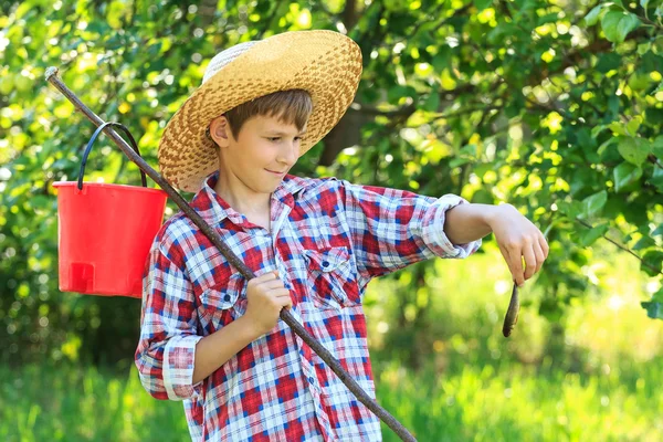 Jongen in stro hoed kijken naar gevangen vis — Stockfoto