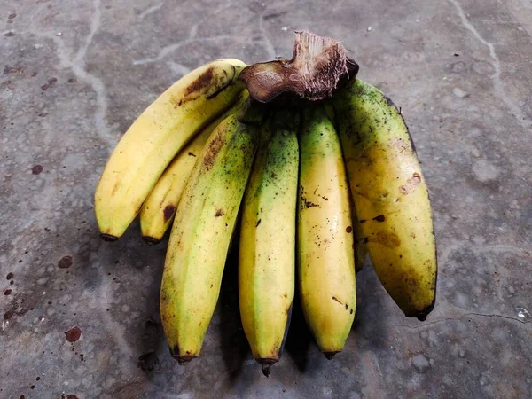 灰色のセメントの背景に隔離された黄色の熟成バナナ果実 — ストック写真