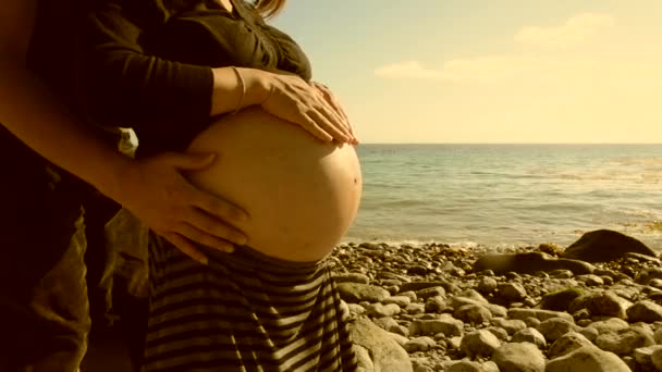 Gravid kvinna med man på stranden — Stockvideo