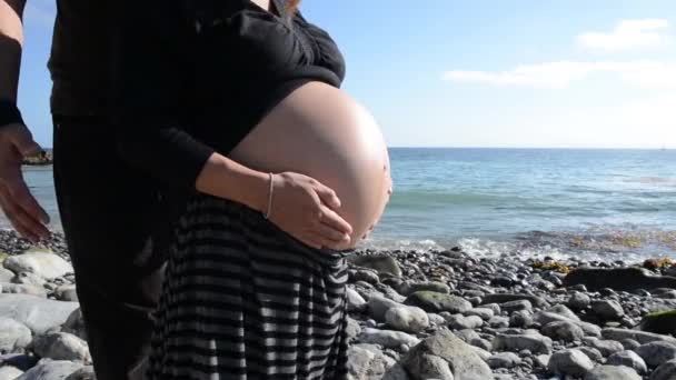 Gravid kvinna med man på stranden — Stockvideo