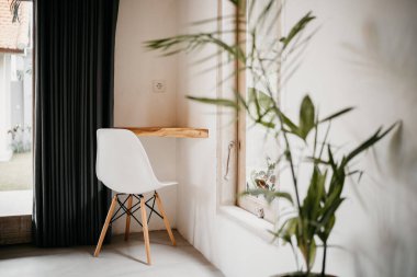 Odanın köşesindeki masada beyaz sandalye. Bir odanın iç köşesi..