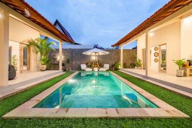 Alacakaranlıkta havuzu olan tatil villaları. Tatil kavramı.